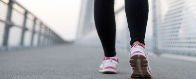 Woman walking across a bridge.